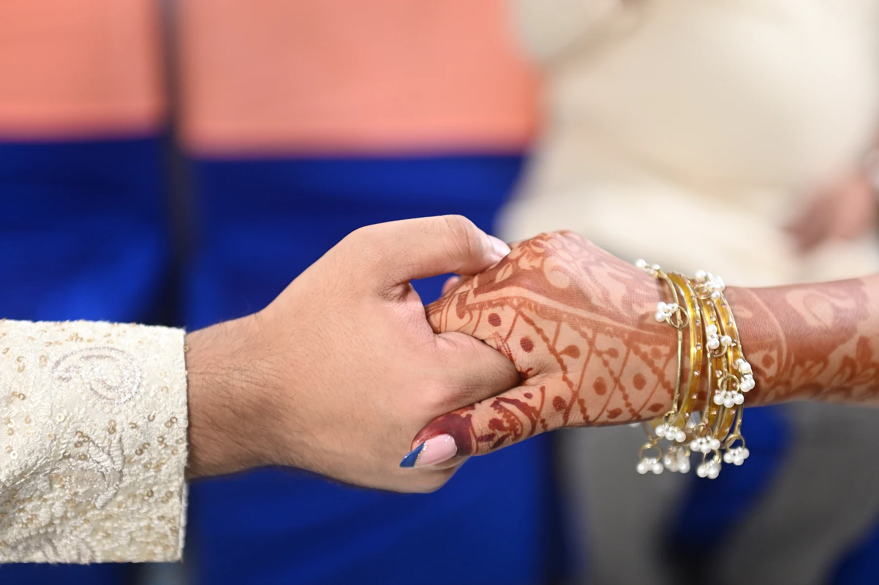 The couple holding hands, with wedding bangles